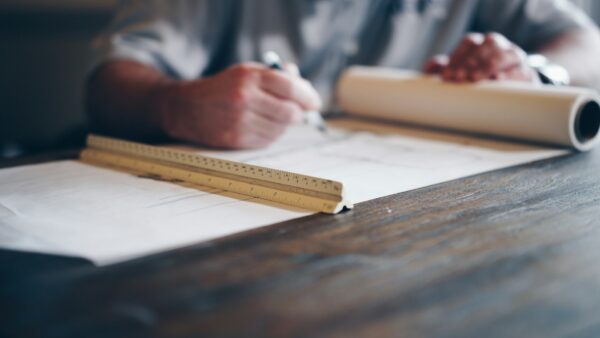 Architect drafting blueprint with ruler
